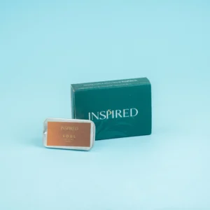 Close-up of a solid perfume tin with warm, romantic fragrance notes.