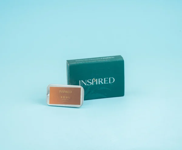 Close-up of a solid perfume tin with warm, romantic fragrance notes.